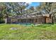Enjoy this private screened-in pool surrounded by lush greenery and mature oak trees on a sunny day at 2690 E Lake Trl, Tarpon Springs, FL 34688