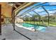 Beautiful screened-in pool area with concrete deck and lush green surroundings at 2690 E Lake Trl, Tarpon Springs, FL 34688