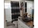 Modern bathroom featuring a decorative sink, neutral color scheme, and shower with a black and silver shower curtain at 28 Sportsman Pl, Rotonda West, FL 33947