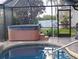 A private hot tub with steps is next to a pool in a screened in lanai at 28 Sportsman Pl, Rotonda West, FL 33947