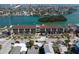 Aerial view of condo building with waterfront access, nearby bridge, and cityscape backdrop at 3111 Pass A Grille Way # 213, St Pete Beach, FL 33706