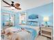Comfortable bedroom with a queen bed, ceiling fan, coastal decor, and plenty of natural light at 3111 Pass A Grille Way # 213, St Pete Beach, FL 33706