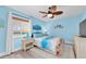 Stylish bedroom featuring a blue and white color scheme, ceiling fan, and a dresser with ample storage at 3111 Pass A Grille Way # 213, St Pete Beach, FL 33706
