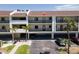 A view of the condo building featuring covered parking, balconies, and landscaping at 3111 Pass A Grille Way # 213, St Pete Beach, FL 33706