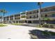 Exterior view of the property, highlighting its multiple balconies, covered parking, and tropical landscaping at 3111 Pass A Grille Way # 213, St Pete Beach, FL 33706