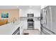 The kitchen features white cabinets, stainless steel appliances, quartz countertops, and a modern design at 3111 Pass A Grille Way # 213, St Pete Beach, FL 33706