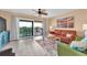 Cozy living room with sliding glass doors to a balcony, wood-look floors, and modern furnishings at 3111 Pass A Grille Way # 213, St Pete Beach, FL 33706