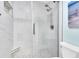 Modern shower featuring glass doors, rainfall shower head, and decorative tiled walls with built-in shelving at 3111 Pass A Grille Way # 213, St Pete Beach, FL 33706