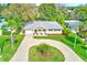 Aerial shot of a landscaped home with a circular driveway and mature trees at 316 Barbara Cir, Belleair, FL 33756