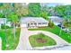 Charming home with a circular driveway, mature landscaping, and a well-manicured front lawn at 316 Barbara Cir, Belleair, FL 33756