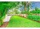 Lush backyard featuring a well-maintained lawn, mature trees, and a charming wooden fence at 316 Barbara Cir, Belleair, FL 33756