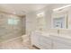 Bright bathroom featuring dual sinks, a glass-enclosed shower, and modern fixtures at 316 Barbara Cir, Belleair, FL 33756