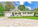 Charming single-story home featuring a covered porch, blue flower pots, and a driveway at 316 Barbara Cir, Belleair, FL 33756