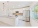 Bright kitchen with a stainless steel refrigerator, new appliances, and an island at 316 Barbara Cir, Belleair, FL 33756