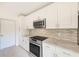 Modern kitchen boasts stainless steel appliances, white cabinets, and stylish backsplash at 316 Barbara Cir, Belleair, FL 33756