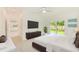 Large main bedroom with a queen-size bed, adjacent bathroom, and back yard access at 316 Barbara Cir, Belleair, FL 33756