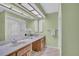 Bright bathroom with double sinks, wood cabinets, and a glass-enclosed shower at 3401 Stonehaven E Ct # A, Palm Harbor, FL 34684