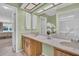 Bathroom with a large mirror, double sinks, and view to bedroom at 3401 Stonehaven E Ct # A, Palm Harbor, FL 34684