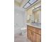 Bright bathroom with a skylight, a tub with white tiles, and a wood vanity with white countertops at 3401 Stonehaven E Ct # A, Palm Harbor, FL 34684