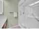 Modern walk-in shower with glass door, white tile, and safety bars at 3401 Stonehaven E Ct # A, Palm Harbor, FL 34684