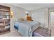 Neutral bedroom featuring a bookshelf, matching sconces, and an upholstered ottoman at the foot of the bed at 3401 Stonehaven E Ct # A, Palm Harbor, FL 34684
