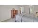 Comfortable bedroom with wood dressers, a view into the hallway and bathroom, and a bed with warm bedding at 3401 Stonehaven E Ct # A, Palm Harbor, FL 34684