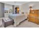 Bedroom with neutral tones featuring a comfortable bed, natural light, and wood accents at 3401 Stonehaven E Ct # A, Palm Harbor, FL 34684