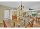 Open dining room features an elegant glass table with view to living areas and bathroom at 3401 Stonehaven E Ct # A, Palm Harbor, FL 34684