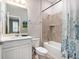 Well-lit bathroom with a shower and tub combo with tiled surround, a white vanity, and a decorative shower curtain at 34303 Radley Way, Wesley Chapel, FL 33545