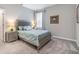 Bedroom featuring a gray bed frame, carpet flooring, and bedside tables with lamps at 34303 Radley Way, Wesley Chapel, FL 33545