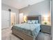 Comfortable bedroom featuring a stylish headboard, bedside tables with lamps, and a well-lit en-suite bathroom at 34303 Radley Way, Wesley Chapel, FL 33545