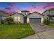 Charming single Gathering home boasting a 2-car garage, manicured lawn, and welcoming stone accents at 34303 Radley Way, Wesley Chapel, FL 33545