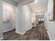 Spacious hallway with hardwood flooring, neutral walls, and views into the living area at 34303 Radley Way, Wesley Chapel, FL 33545