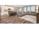 Open-concept living area features wood-look floors, modern furniture, and a kitchen with bar seating at 34303 Radley Way, Wesley Chapel, FL 33545