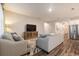 Spacious living room with modern furniture, wood-look flooring, and a large television at 34303 Radley Way, Wesley Chapel, FL 33545