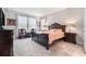 Bedroom boasts a dark wood bed frame, carpet flooring, and decorative window curtains at 34303 Radley Way, Wesley Chapel, FL 33545