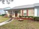 Charming single-story home with a brick facade, covered porch, and well-maintained front yard at 35118 Whispering Oaks Blvd, Dade City, FL 33523