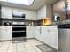 Bright kitchen featuring white cabinets, granite countertops, stainless appliances, and tile flooring at 35118 Whispering Oaks Blvd, Dade City, FL 33523