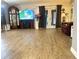 Open living room with wood-look flooring, a modern entertainment center, and access to the outdoors at 35118 Whispering Oaks Blvd, Dade City, FL 33523