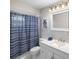 Bathroom with a white vanity and toilet and a shower with blue striped curtain at 3515 Centavo Ct, Hernando Beach, FL 34607