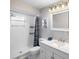 Modern bathroom features a white vanity and shower with blue accent curtain at 3515 Centavo Ct, Hernando Beach, FL 34607