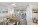 Elegant dining room with a large wooden table, contemporary chairs, and natural light from sliding glass doors at 3515 Centavo Ct, Hernando Beach, FL 34607