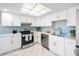 Modern kitchen with white cabinetry, stainless steel appliances, and a view of the water and outdoor space at 3515 Centavo Ct, Hernando Beach, FL 34607