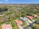 Aerial view of homes in a lush neighborhood with golf course, surrounded by mature trees and landscaping at 3819 Brooksworth Ave, Tarpon Springs, FL 34688