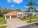 Aerial view of home with beautiful landscaping, brick driveway, and a tile roof at 3819 Brooksworth Ave, Tarpon Springs, FL 34688