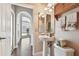 Charming bathroom featuring a pedestal sink, decorative mirrors, and updated fixtures, providing a cozy and functional space at 3819 Brooksworth Ave, Tarpon Springs, FL 34688