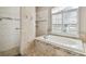 Bright bathroom featuring a large garden tub and tiled shower at 3819 Brooksworth Ave, Tarpon Springs, FL 34688