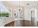 Bright dining area featuring wood floors, chandelier, and sliding glass doors to the screened-in lanai with pool at 3819 Brooksworth Ave, Tarpon Springs, FL 34688