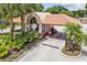 Community gate house entrance with lush tropical landscaping featuring palms and a directional sign at 3819 Brooksworth Ave, Tarpon Springs, FL 34688