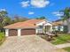 Attractive single-story home with lush tropical landscaping, paver driveway, and tile roof at 3819 Brooksworth Ave, Tarpon Springs, FL 34688